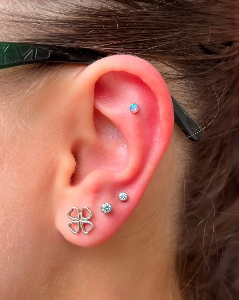 Piercing ureche cu opal și bijuterii fine realizat de Doris la Muntele Tattoo